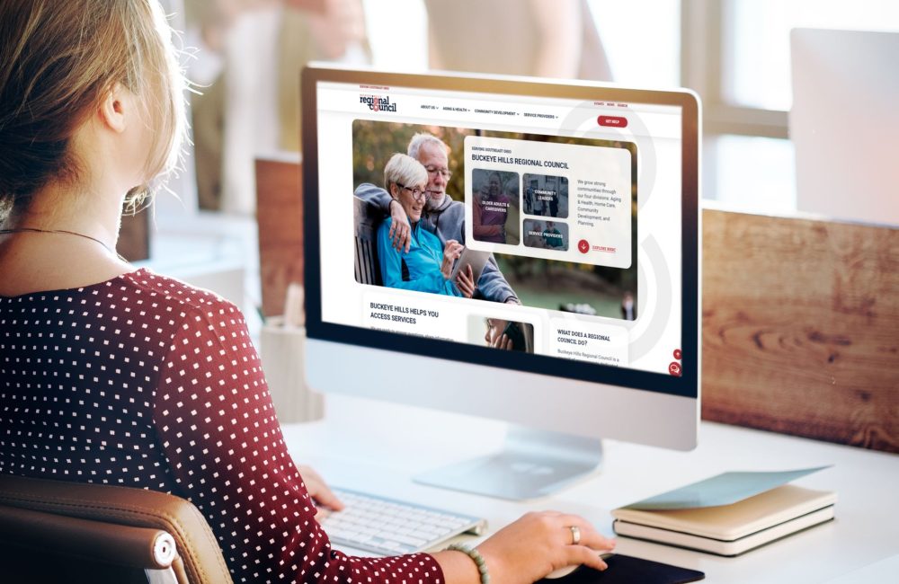 Woman at desk looking at Buckeye Hills Regional Council Desktop Mockup