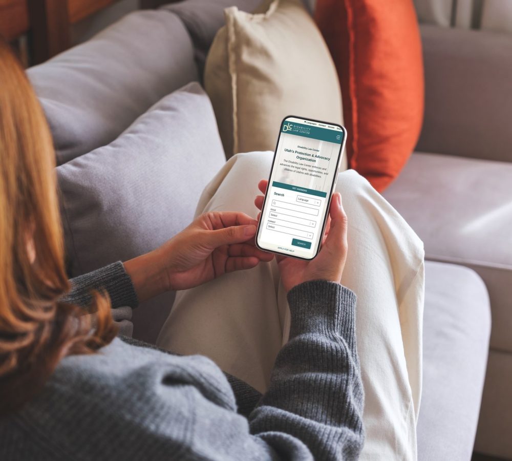 Woman on couch looking at Disability Law Center Mobile Mockup
